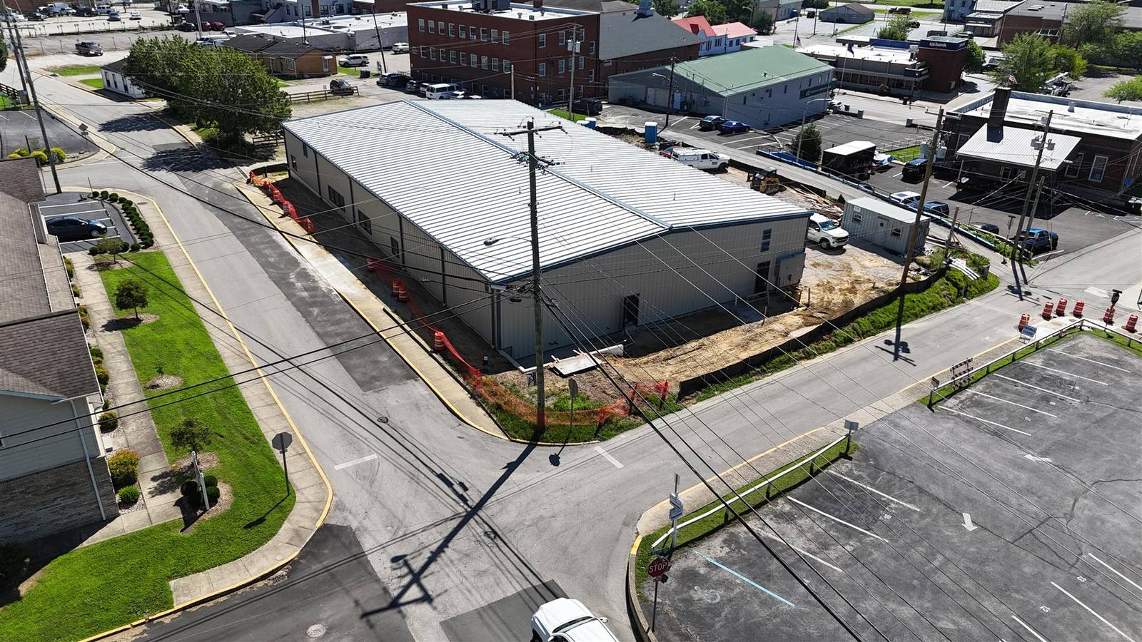 Front aerial of the enclosed building and gravel site, July 2026